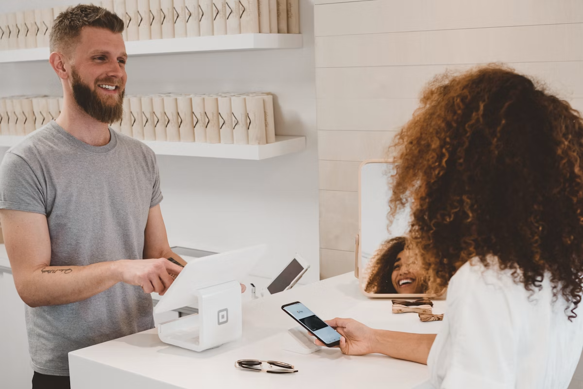 Cliente payant avec son téléphone à une caisse de magasin moderne